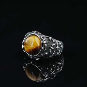 Vintage bat engraved silver ring with a large tiger eye stone on black mirror