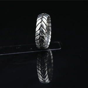 Retro stainless steel tire pattern ring with oxidized silver finish on a black mirror base