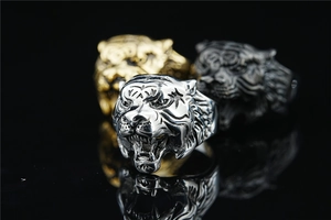 Macro detail of lion head rings in silver, gold, and black finishes with 3D engraving