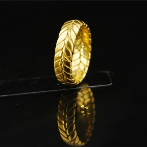 Golden tire-tread textured ring with wheat pattern engraving and mirror reflection