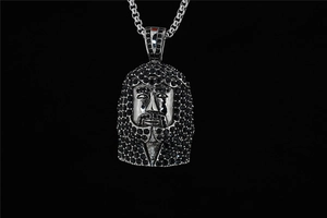 Detailaufnahme der silbernen Hip-Hop Jesus-Kette mit schwarzen Strasssteinen besetzt