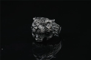 Close-up of vintage silver lion head ring featuring intricate textured roaring details