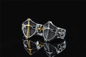 Detail of gothic shield rings with vintage cross swords and fleur-de-lis engravings