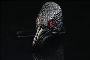 Macro shot of gothic eagle ring featuring detailed feather textures and red gem eyes