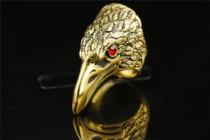 Macro detail of vintage eagle head ring with red gem eyes and aged gold finish