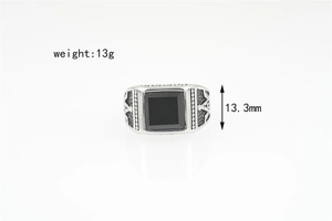 Detail showing the 13.3mm square black stone and vintage engraved texture on a men's ring