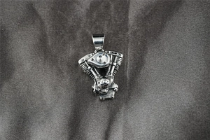 Macro shot of silver-toned V-Twin engine pendant with detailed mechanical cooling fins