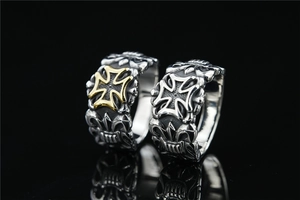 Macro shot of retro iron cross and fleur-de-lis engraving on men's punk style rings