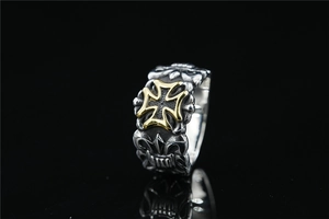 Detailed close-up of a vintage gothic ring featuring a gold iron cross on silver metal