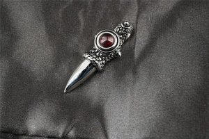 Close-up of gothic dragon claw pendant with red gemstone and detailed metal scales