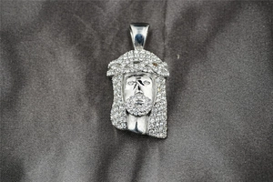 Macro shot of iced out silver Jesus pendant with detailed micro-pave crystal settings