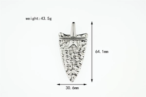 Close-up of vintage silver arrow pendant with hammered texture and rope detail