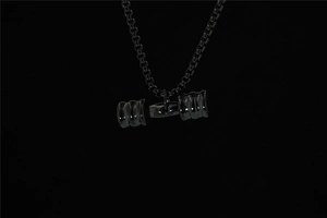 Detailed view of solid black dumbbell pendant on a box chain for fitness lovers