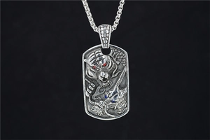 Détail macro du pendentif vintage en acier titane avec relief dragon et tigre gravé
