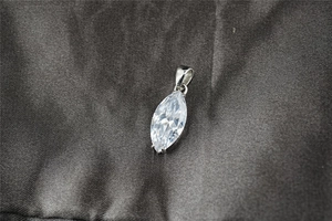 Dettaglio del ciondolo in moissanite taglio marquise con chiusura argentata su seta
