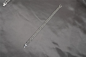 Detail of silver cuban link bracelet showing the classic thick flat-cut design and clasp