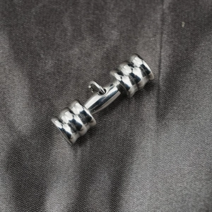 Polished silver dumbbell pendant necklace for men and women on a dark textured background