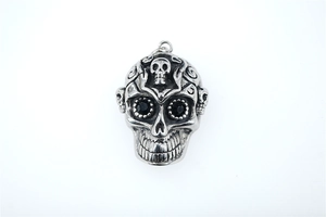 Gros plan d'un pendentif crâne gothique punk avec gravures et pierres noires facettées