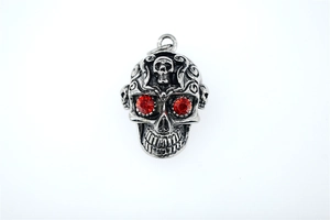 Détail du pendentif crâne gothique avec yeux en gemme rouge et finition argent vieilli