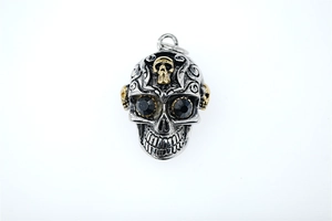 Détail du pendentif crâne punk avec accents dorés et yeux en pierres précieuses noires