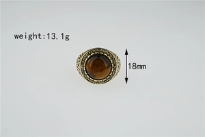 Macro detail of vintage tiger eye ring with golden wave engraving and black zircon accents