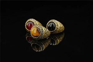 Macro shot of vintage titanium steel rings with tiger eye and obsidian insets on black base