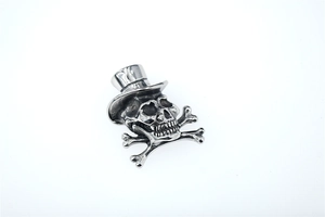 Détail d'un pendentif tête de mort vintage en argent avec chapeau et os croisés