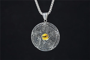 Gros plan du pendentif œil de dragon gothique avec pupille jaune et gravure étoile