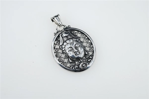 Macro shot of silver hollowed oval pendant featuring an intricate Guanyin Buddha relief