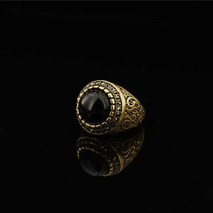 Vintage gold steel ring with black gemstone center and intricate floral carvings