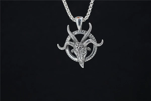 Macro shot of silver Baphomet goat head pendant with pentagram detail and gothic chain link