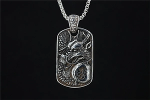 Macro view of vintage embossed dragon pendant with engraved Chinese character on silver metal