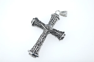 Detail of vintage silver cross pendant with intricate floral engravings and Jesus relief
