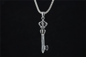 Macro detail of retro crown key pendant with vajra carving on vintage silver chain