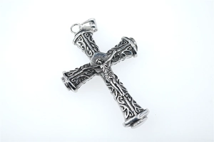 Macro detail of vintage silver cross pendant with Jesus relief and ornate engraving