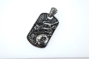 Detail of vintage embossed dragon pendant with traditional Chinese dragon pattern