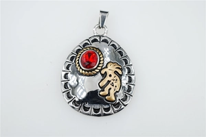 Close-up of retro ethnic pendant with red gemstone and golden Kokopelli detail