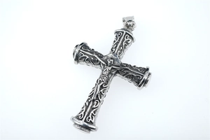 Detail of vintage silver crucifix pendant with intricate vine relief and Jesus figure