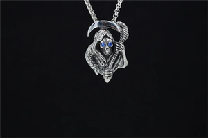 Detailed view of punk Grim Reaper pendant with blue gemstone eyes and scythe on black