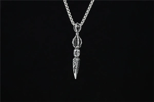 Detail of vintage silver Vajra pestle pendant with Buddhist engravings on a box chain