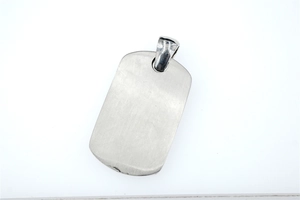 Detailed macro view of brushed stainless steel dog tag pendant with polished silver bail