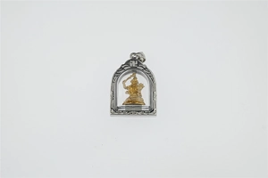 Detailansicht eines silbernen Buddha-Anhängers aus Titanstahl mit goldener Gottheitsfigur