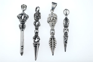 Detailed close-up of retro silver Vajra and Ganesha amulets with antique finish