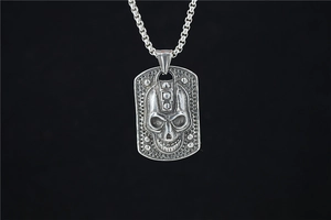 Close-up of vintage punk skull military tag pendant with textured silver metal finish