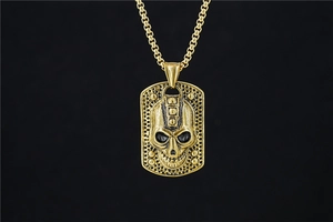 Detailed macro view of a gold skull rectangular pendant with gothic punk metal texture