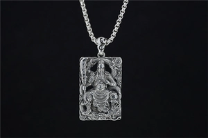 Macro detail of Guan Yu warrior pendant with dragon relief and box chain in vintage silver