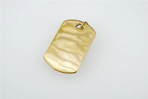 Macro detail of rectangle matte gold skull pendant with unique water ripple texture