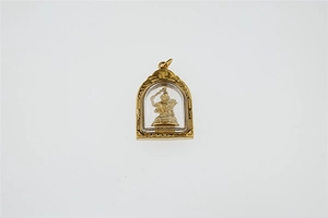 Detailansicht eines goldenen buddhistischen Anhängers mit Relief und religiösen Symbolen