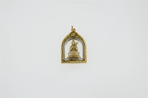Detailansicht eines goldenen Buddha-Anhängers in Bogenform mit traditioneller Gravur
