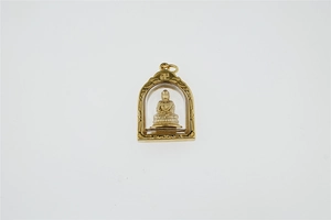 Nahaufnahme des goldenen Buddha-Anhängers mit Reliefschnitzerei und Schutzkuppel